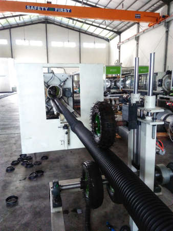 Production of corrugated pipe. The process of making single wall corrugated pipes on the machine in the factory.のeditorial素材