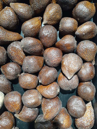 A bunch of salak fruit on a supermarket shelf.