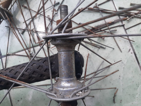 Old bicycle wheel with rusty wire in the garage. Selective focus.の写真素材