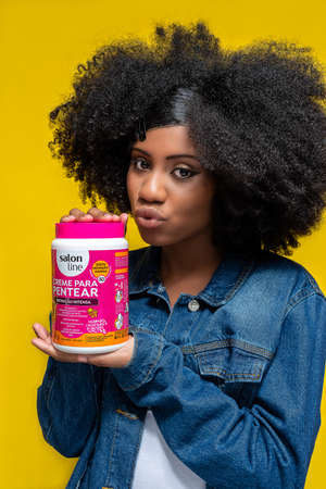 SÃƒO PAULO, BRAZIL - OCTOBER, 13, 2020 AFRO BRAZILIAN GIRL DRIES TO PENTAR CREAM CREAM FROM THE...