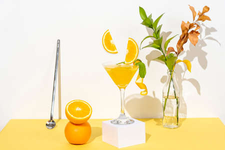 orange drink on a table with yellow carving and white background, oranges as decorationの写真素材