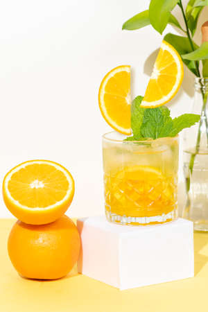 glass with chilled orange drink, two orange slices falling into the glass, refreshing summer cocktailの写真素材
