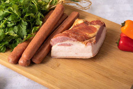 ingredients for preparing a recipe, bacon sausage, parsley, vegetables, on a table