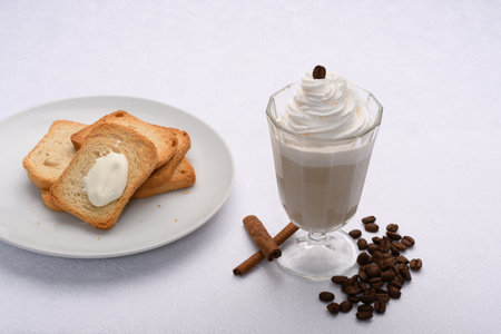 Coffee with whipped cream and toasted bread on white backgroundの写真素材