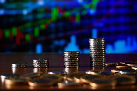 Pile of coins with stock market chart background. Business and finance concept.の写真素材