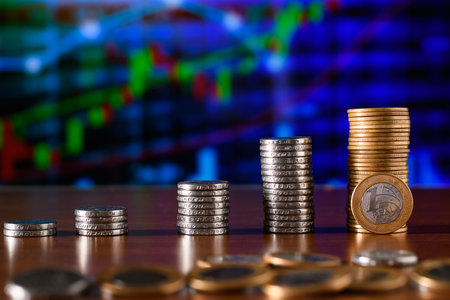 Stack of coins on the table with the background of the financial chartの写真素材
