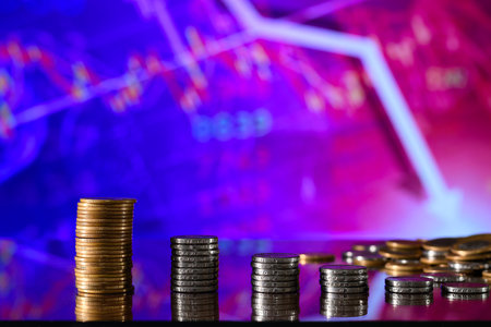 Coins stacked on each other in different positions, with the background of the stock exchange chart.の写真素材