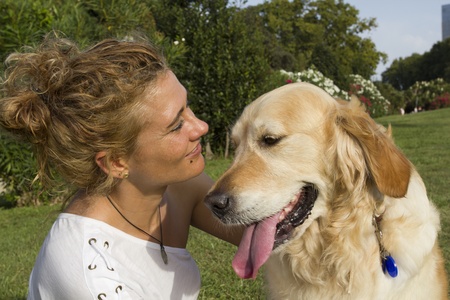 Girl in a park hugging her dogの写真素材
