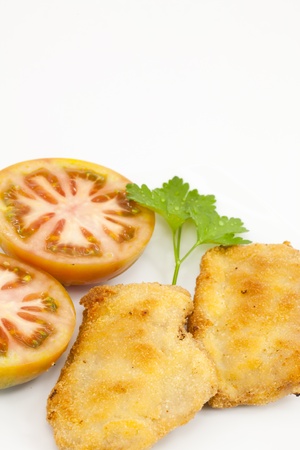 Breaded pork loin with tomato and parsley adorningの写真素材