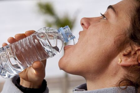 Girl drinking water after physical exertion