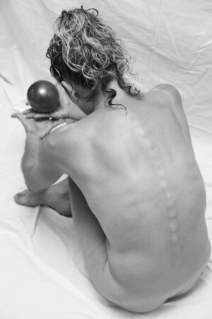 unclothed girl with a ball in handsの写真素材