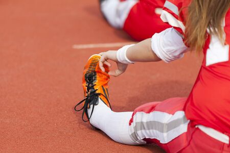 American female soccer players performing pregame stretching