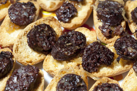 Black sausage with caramelized onions and toastの写真素材