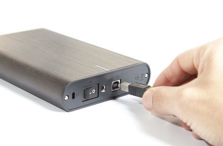 By connecting a portable hard drive on a white background