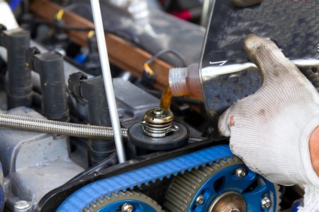 Mechanic fill engine oil in a competition