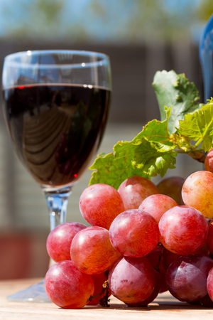 Black wine glass with freshly harvested grapesの写真素材