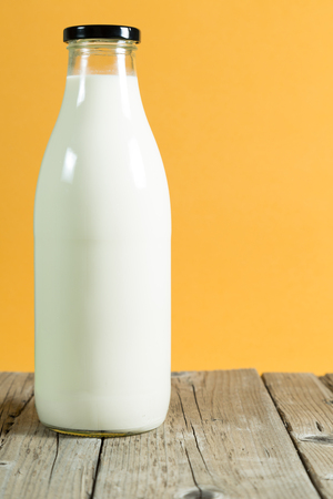 Milk bottle on a table with color backgroundの写真素材