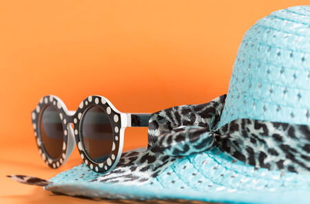 Beach hat and sunglasses with orange backgroundの写真素材