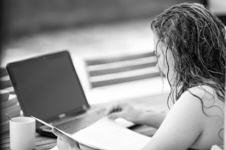 Studying a girl outdoors with her laptop and notesの写真素材