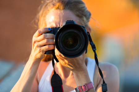 Pretty woman is a professional photographer with slr cameraの写真素材