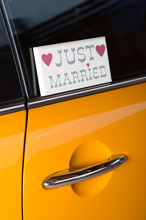Newlyweds in his orange car to travel on honeymoonの写真素材