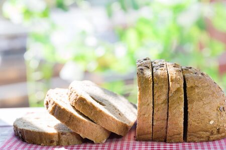 Cut loaf of bread with cereals on the table