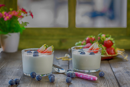 Yogurt with berries and strawberries into piecesの写真素材