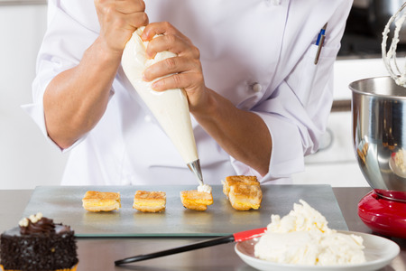 Chef decorating with a pastry bag with creamの写真素材
