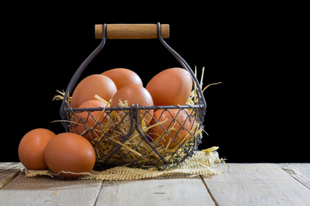 Wire basket with eggs and black backgroundの写真素材