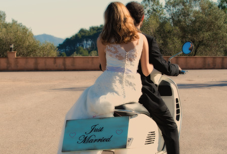 Newlywed couple leaving the wedding with their motorbikeの写真素材