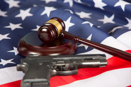 Judge gavel with the United States flag and a pistolの写真素材