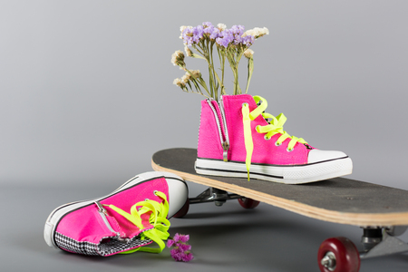 Sneakers and skateboard decorated with flowersの写真素材