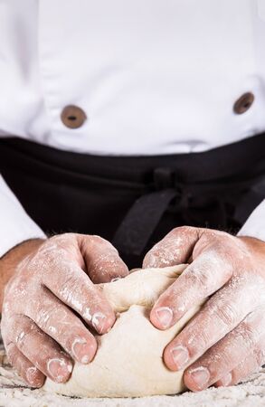 Baker kneading dough with flour and waterの写真素材
