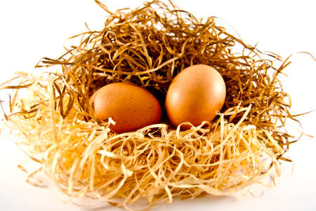 two eggs lying on the straw of which may appear chickensの写真素材