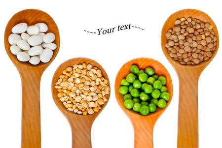 four wooden spoons with bean and pea seeds on a white backgroundの写真素材