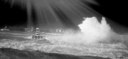 lighthouse on the breakwater and broken waveの写真素材