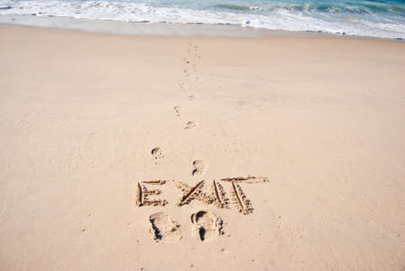 traces of man and the word "exit" in the sand,の写真素材