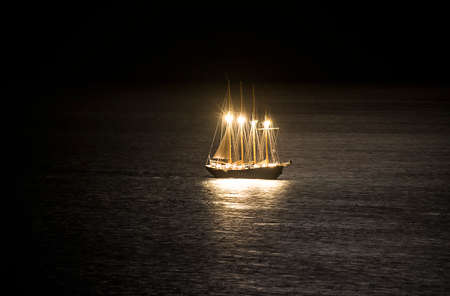 sailboat in the sea at night svte its illuminationの写真素材