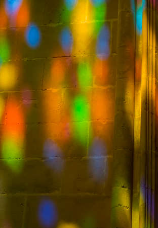 glare from the stained-glass windows on a stone wallの写真素材