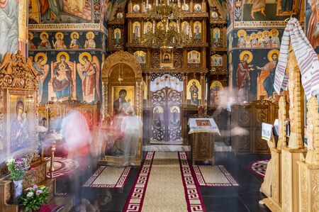 Long exposure with silhouettes of people worshipping icons in an orthodox church.のeditorial素材