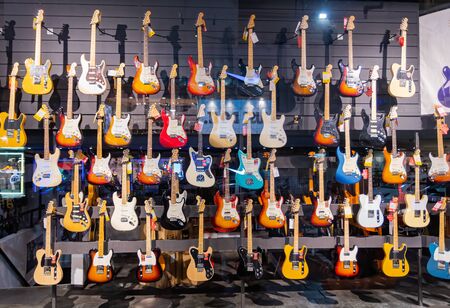 Tens of colorful electric guitars displayed in a music store.