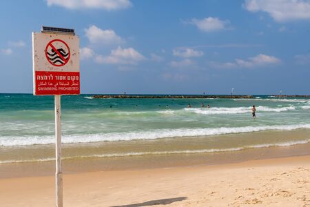 People swimming in a forbidden area ignoring the signs prohibiting this.のeditorial素材