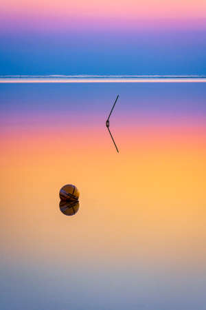 Long exposure abstract landscape with circle and line reflecting in colorful water.の写真素材