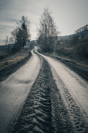 Country road. Dirt road in the countryside with trees and hills - retro vintage effect.の写真素材