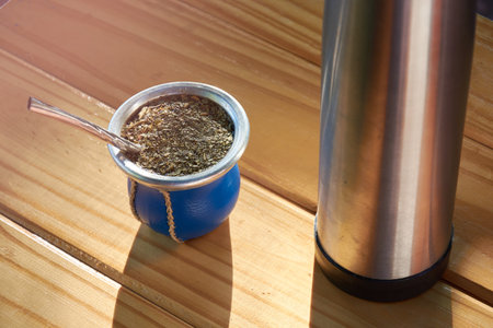 Top view of traditional Argentine mate on rustic wooden table. Hot herbal infusion traditional from...