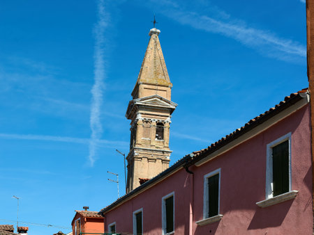 View from the top of the Leaning Bell Tower of the Church of San Martino Vescovo against a blue sky on a spring day in Burano, Italy.の写真素材
