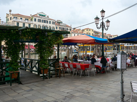 MAY 20, 2017 - VENICE, ITALY: People having lunch at eatery place "Ristorante Omnibus" next to gondola stand with the Grand Canal in the background in Venice.のeditorial素材