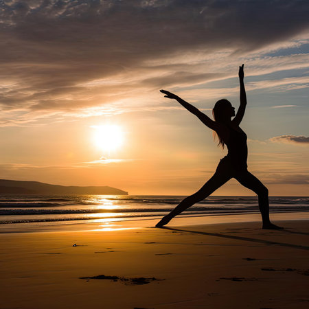 Silhouette of a woman practicing yoga on the beach at sunsetの素材