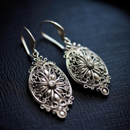 Silver earrings on a black background, close-up, selective focusの素材