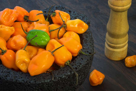 Habanero Yellow Chili Hot Peppers in volcanic stone bowlの写真素材